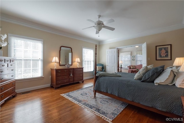 bedroom featuring baseboards, visible vents, a ceiling fan, ornamental molding, and wood finished floors