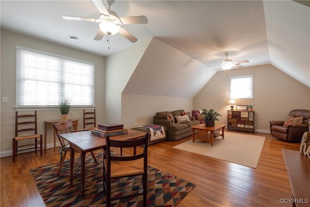 interior space with ceiling fan, baseboards, vaulted ceiling, and wood finished floors