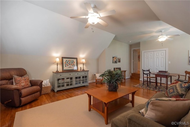 living area featuring a ceiling fan, lofted ceiling, and wood finished floors