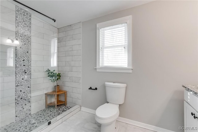 bathroom with toilet, vanity, baseboards, and walk in shower