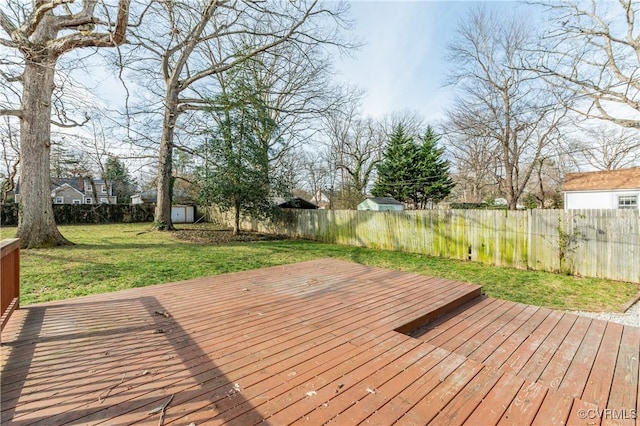 wooden terrace featuring a storage shed, a yard, an outdoor structure, and a fenced backyard