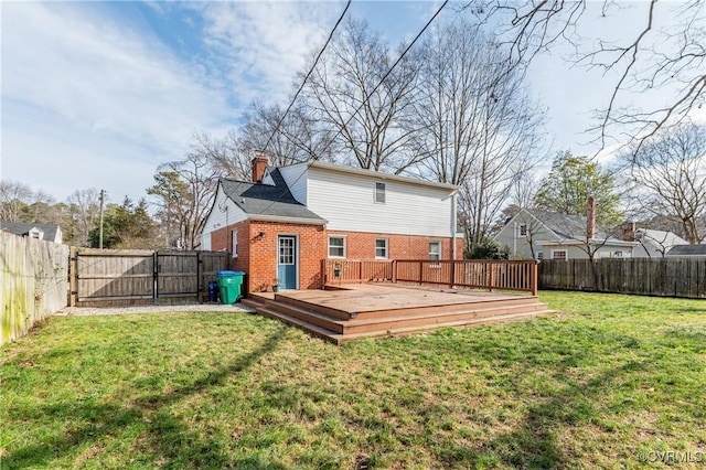 back of property with brick siding, a lawn, a chimney, and a fenced backyard