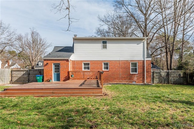 back of house featuring a deck, a yard, brick siding, and a fenced backyard