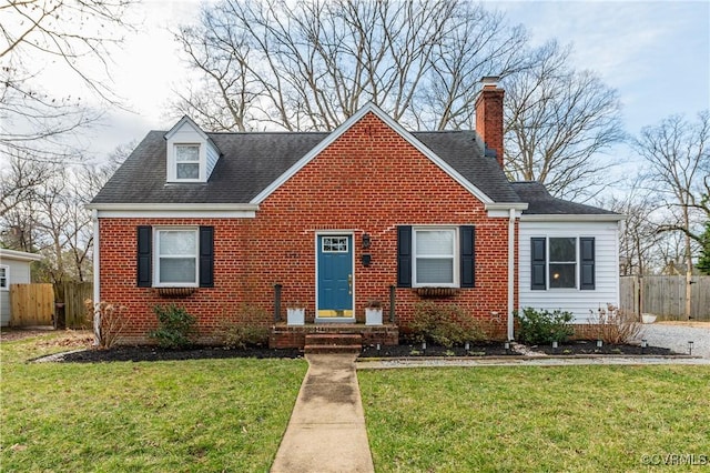 view of front facade with brick siding, fence, a chimney, and a front lawn