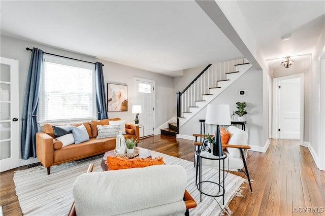 living room featuring stairs, wood finished floors, and baseboards