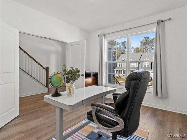 home office with baseboards and wood finished floors