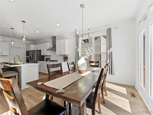 dining room featuring visible vents, baseboards, light wood-style floors, a chandelier, and recessed lighting