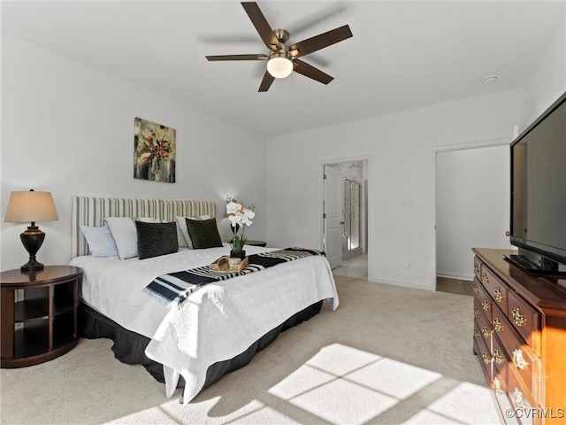 bedroom with light carpet, baseboards, and a ceiling fan