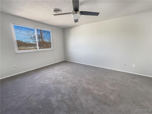 carpeted spare room with ceiling fan and a textured ceiling