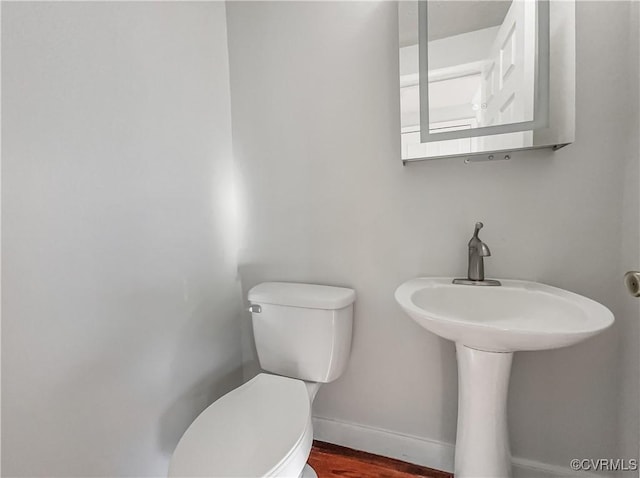 bathroom with hardwood / wood-style floors and toilet