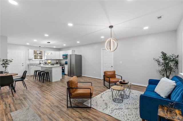 living room featuring sink and hardwood / wood-style floors