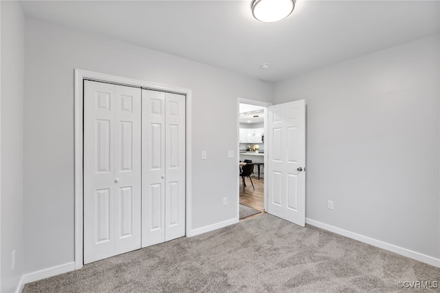 unfurnished bedroom with light colored carpet and a closet