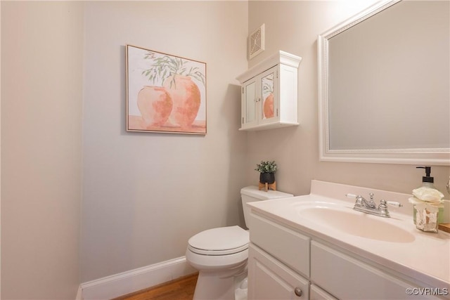 bathroom featuring baseboards, visible vents, vanity, and toilet