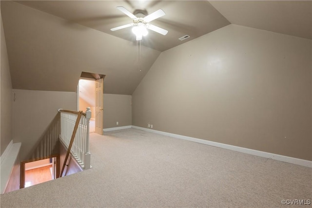 bonus room featuring ceiling fan, light colored carpet, visible vents, baseboards, and vaulted ceiling