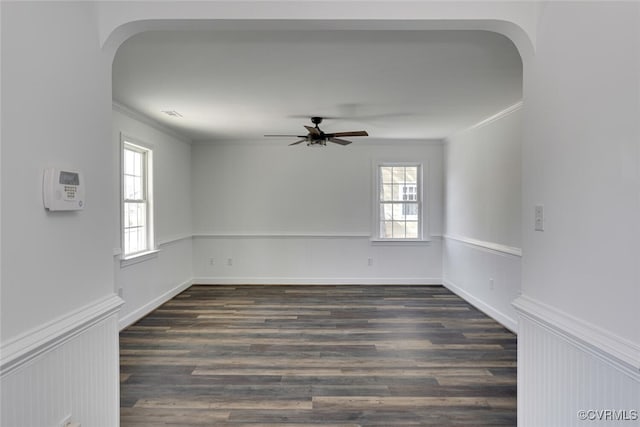 empty room featuring ceiling fan, ornamental molding, and dark hardwood / wood-style floors