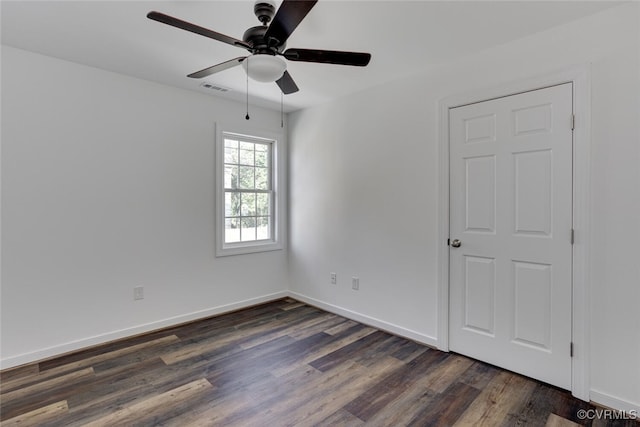 unfurnished bedroom with ceiling fan and dark wood-type flooring