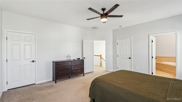 carpeted bedroom featuring ceiling fan and ensuite bath