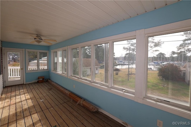 unfurnished sunroom with a water view and ceiling fan