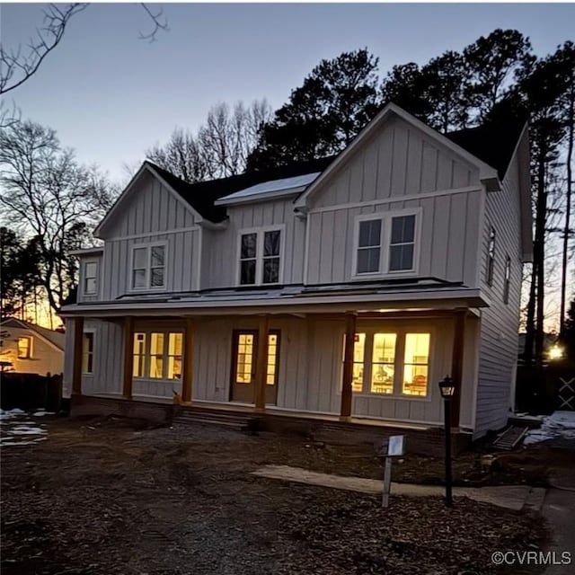 back of house with covered porch and board and batten siding