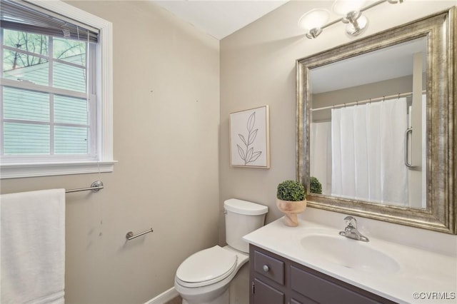 bathroom featuring toilet, a wealth of natural light, and vanity