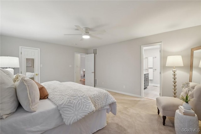 bedroom featuring ceiling fan, ensuite bath, and light colored carpet