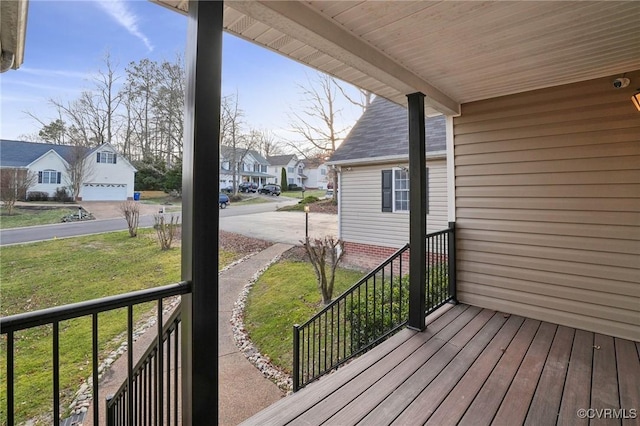 deck featuring a garage, a yard, and a porch