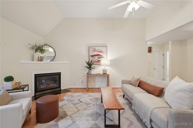 living room with light wood-type flooring, lofted ceiling, and ceiling fan