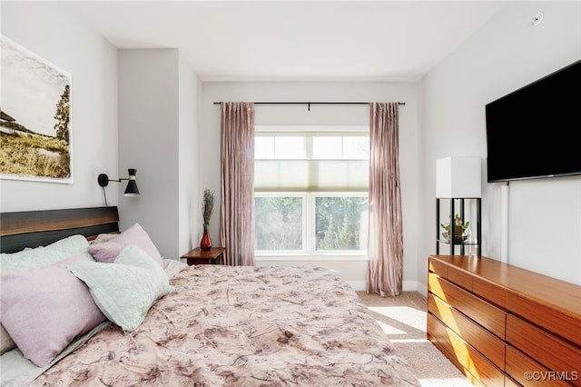 bedroom featuring light carpet and baseboards