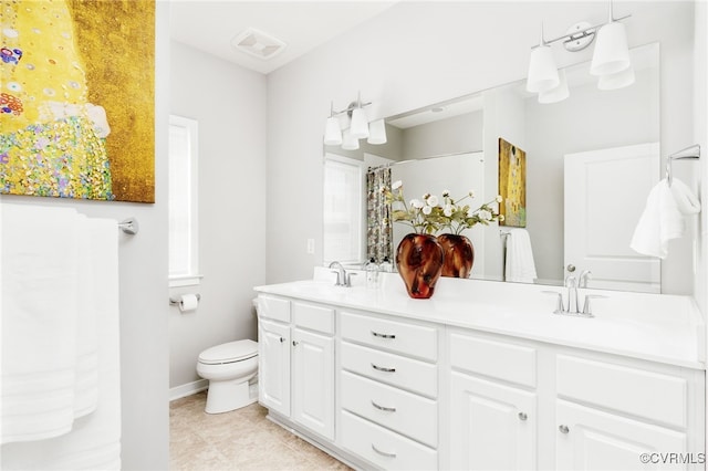 full bath featuring toilet, double vanity, a sink, and visible vents