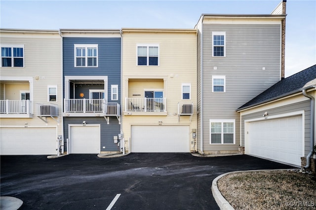 view of front of home featuring a garage, driveway, and a wall mounted AC