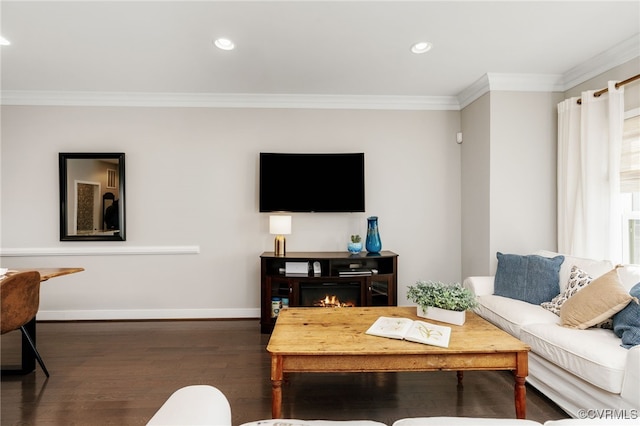 living area featuring recessed lighting, wood finished floors, baseboards, a lit fireplace, and crown molding