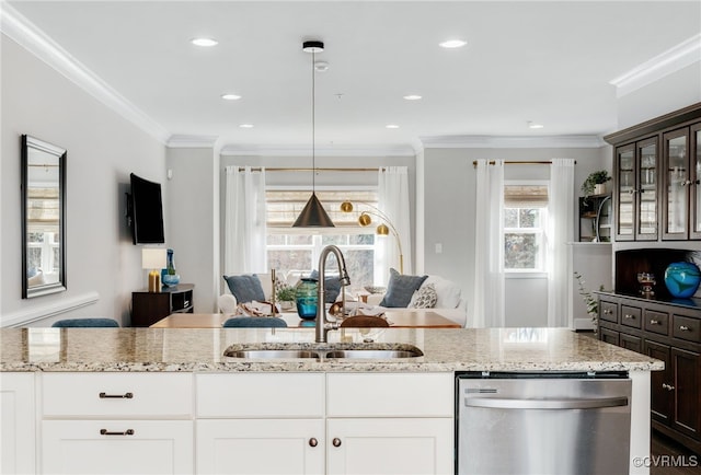 kitchen with dishwasher, light stone counters, open floor plan, and a sink