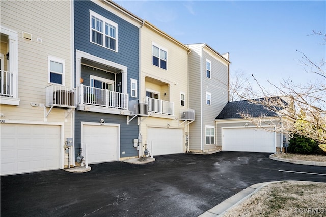 view of property with driveway, central AC, and an attached garage