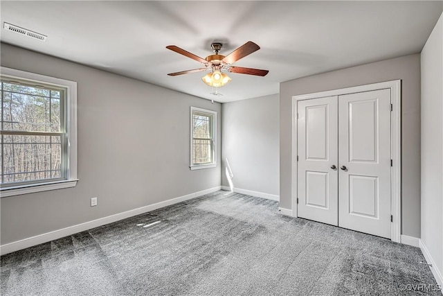 unfurnished bedroom with visible vents, baseboards, a closet, and carpet flooring