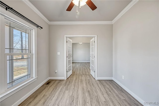 empty room with visible vents, light wood-style floors, baseboards, and ornamental molding