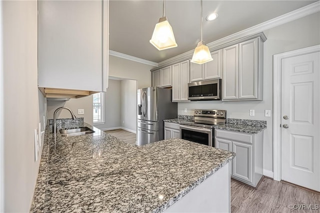 kitchen featuring crown molding, light wood-type flooring, stone countertops, stainless steel appliances, and a sink