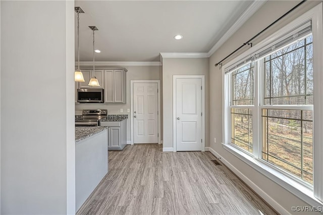 kitchen featuring ornamental molding, visible vents, baseboards, and stainless steel appliances