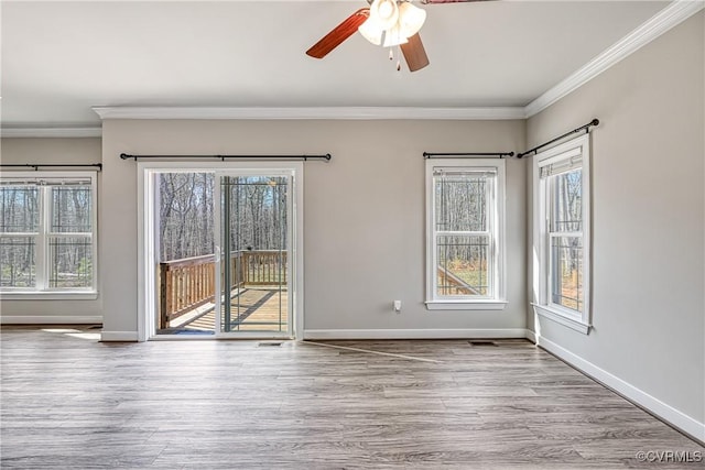 unfurnished room featuring a ceiling fan, crown molding, wood finished floors, and baseboards