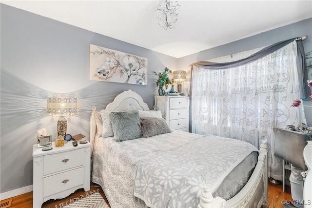 bedroom with baseboards and dark wood-style flooring