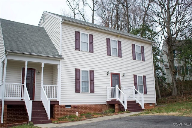 colonial-style house with covered porch, a shingled roof, and crawl space
