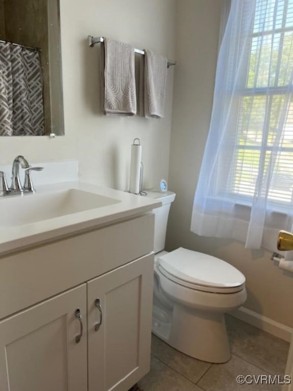 bathroom with vanity, tile patterned flooring, a wealth of natural light, and toilet