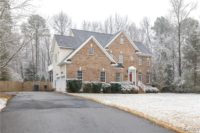 view of front of home featuring brick siding and fence