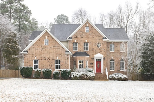 view of front of house featuring brick siding and fence