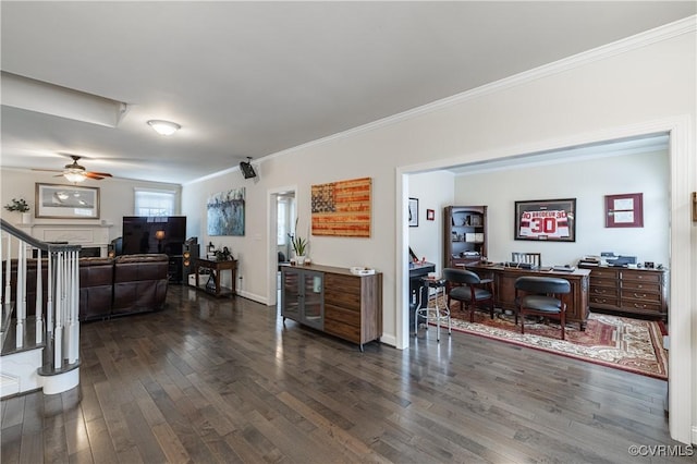 living room featuring dark wood-style floors, ornamental molding, ceiling fan, and stairs