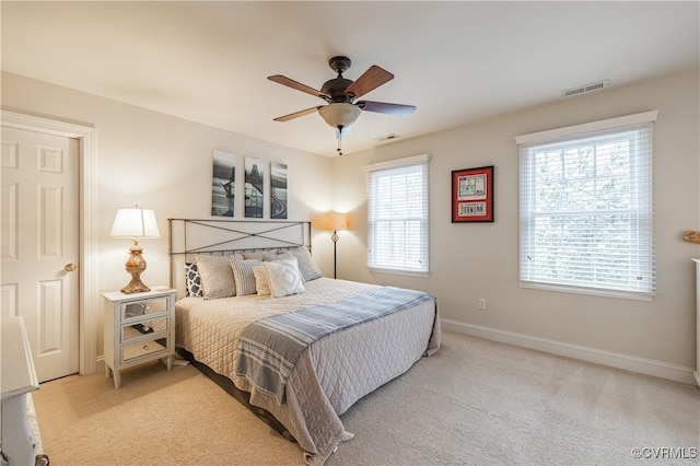 bedroom with light carpet, visible vents, and baseboards