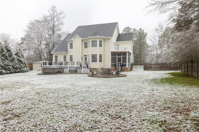 back of house with a deck, a sunroom, a fenced backyard, and a fire pit