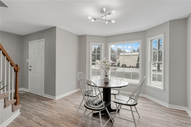 dining room with light hardwood / wood-style floors and a chandelier