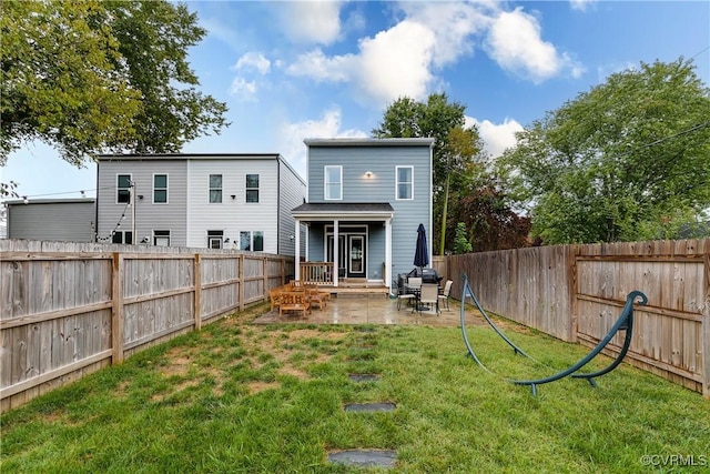 back of house with a lawn, a patio area, and a fenced backyard