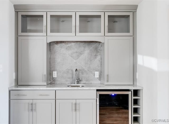 bar featuring indoor wet bar, wine cooler, decorative backsplash, and a sink