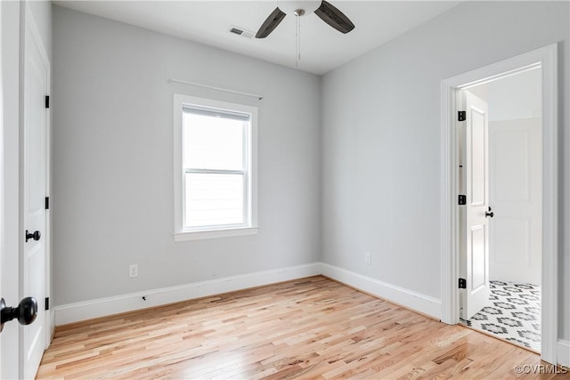 unfurnished room featuring baseboards, a ceiling fan, visible vents, and light wood-style floors